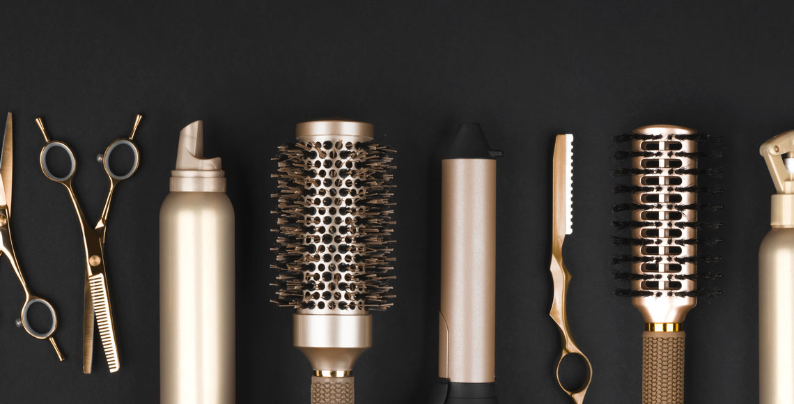 Collection of professional hair dresser tools arranged on dark background
