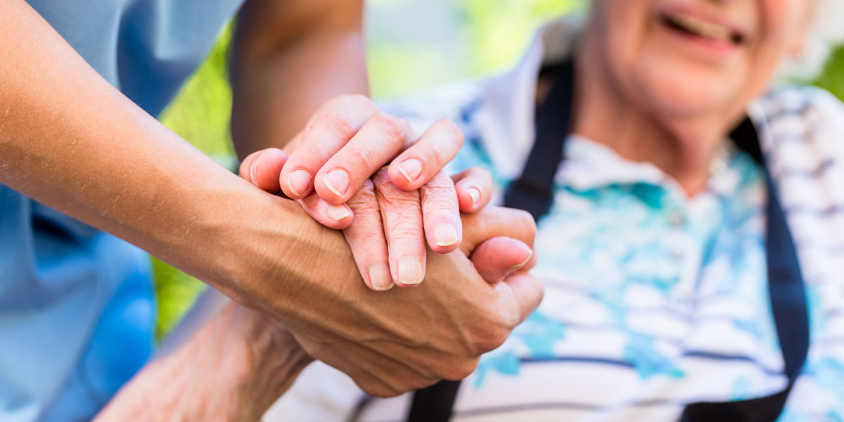 Nurse consoling senior woman holding her hand