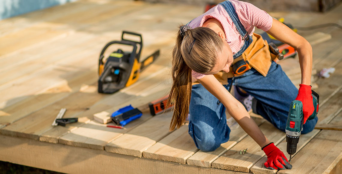 Carpenter woman is at work. Building as a hobby. Beautiful woman with construction tools