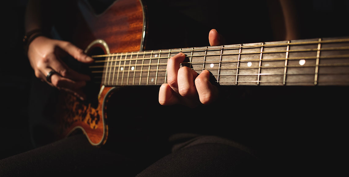 Woman playing a guitar in music school