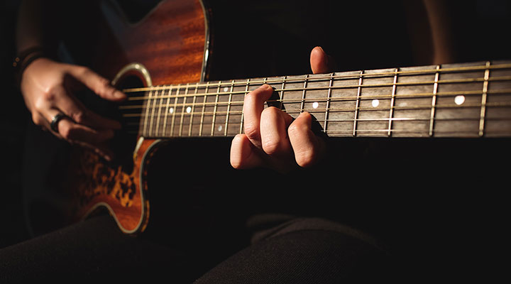 Woman playing a guitar in music school