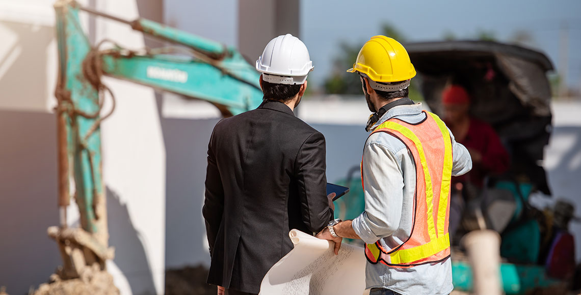 Construction worker and engineer working together on construction site.