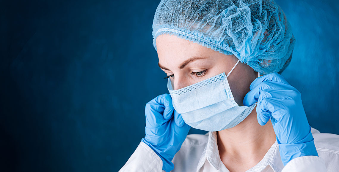 female doctor puts on a mask