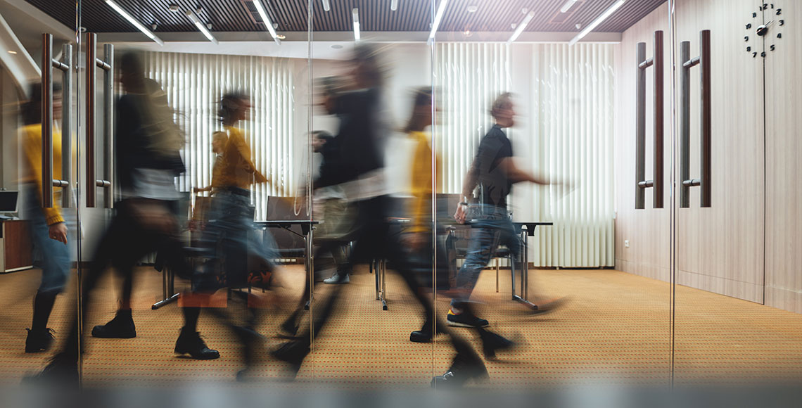 Businesspeople walking at modern office. Group of business employees at coworking center. Motion blur. Concept work process. Wide image