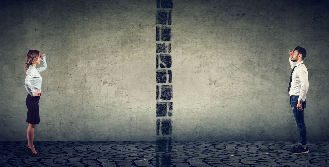 Gender gap, inequality and broken communication concept. Business man and woman separated from each other by a wall