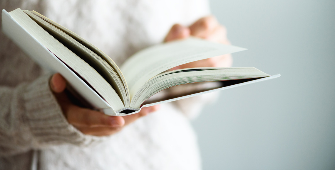 Young girl in white T-shirt reading opened book. Copy space. lifestyle and school concept